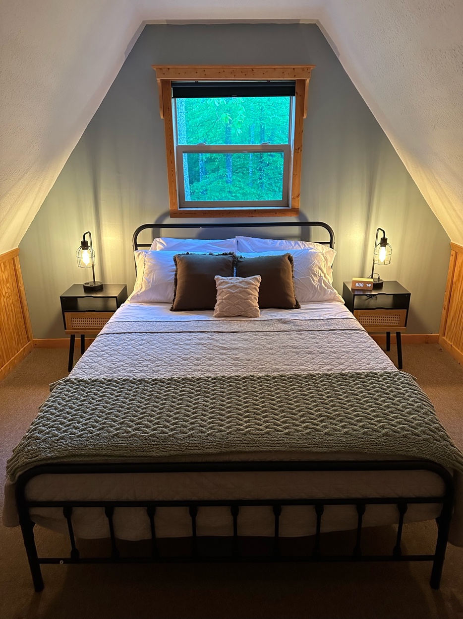 Queen bedroom with lush forest window view